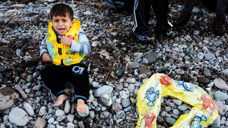 Un niño llora a su llegada a la costa de Lesbos.