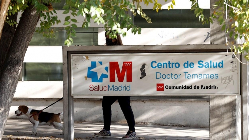 Una vecina pasea a su perro en los alrededores del centro de salud Doctor Tamames, este lunes, en el municipio madrileño de Coslada