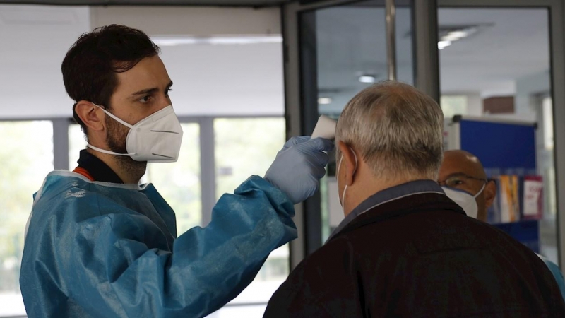 Personal sanitario del SERMAS toma la temperatura a una persona en la entrada de una residencia de mayores.