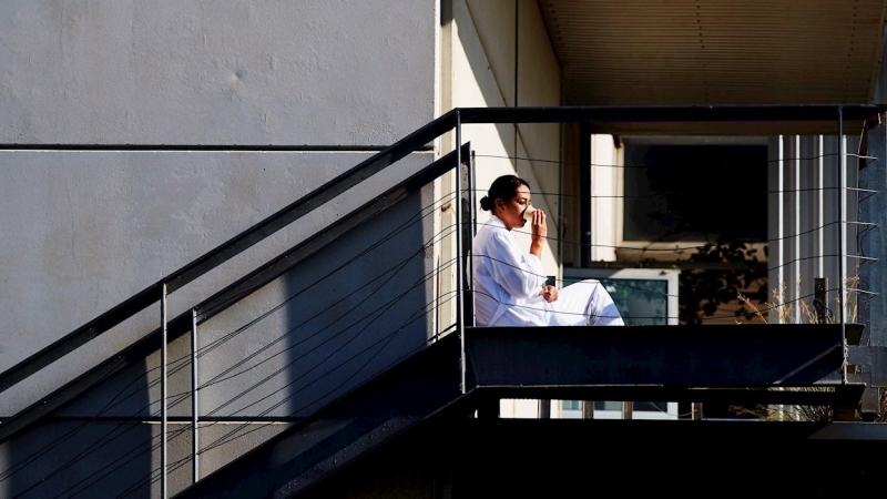 Una sanitaria descansa fuera de un hospital.