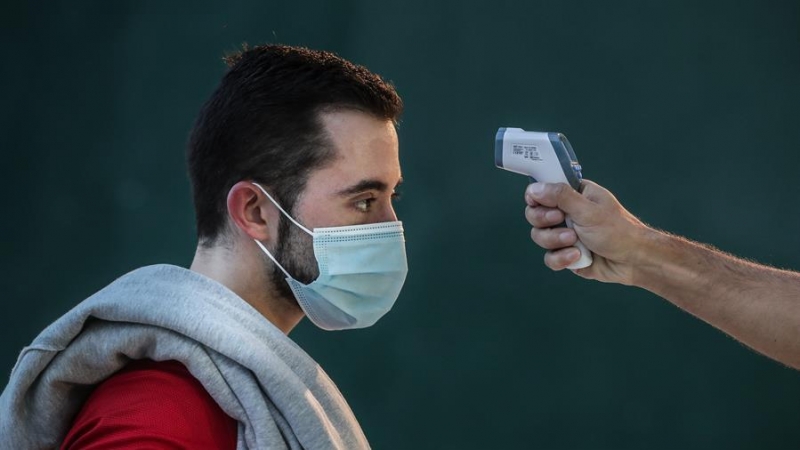 Imagen de un hombre mientras le toman la temperatura