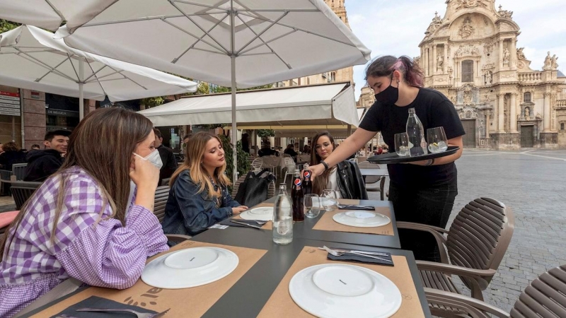 Una camarera sirve la bebida en la mesa de la terraza de un restaurante este miércoles en la Plaza Cardenal Belluga de Murcia.