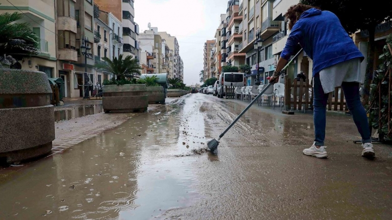 Una vecina retira agua de la calle, en Cullera (València) , donde han caído mas de 100 litros.