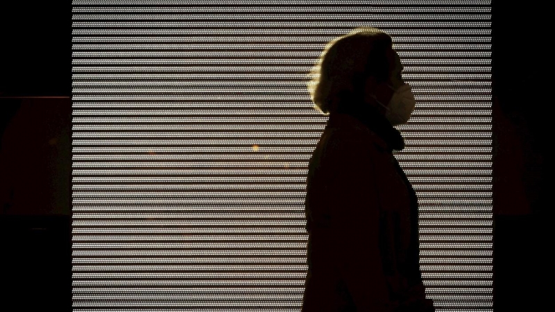 Imagen de una mujer con mascarilla paseando