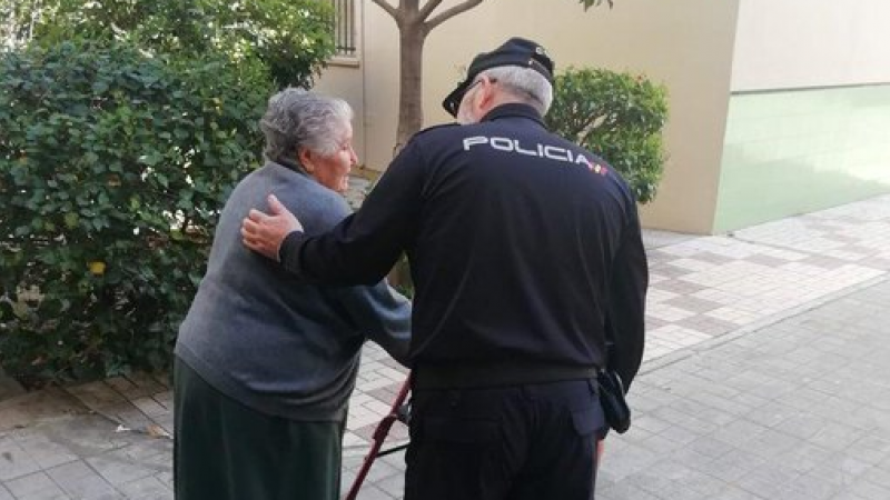 Un agente ayuda a una mujer mayor. - Twitter de la Policía Nacional