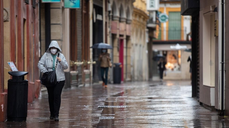 Transeúntes por la calle Sagasta durante una jornada de lluvia. En Sevilla (Andalucía, España), a 22 de octubre de 2020.