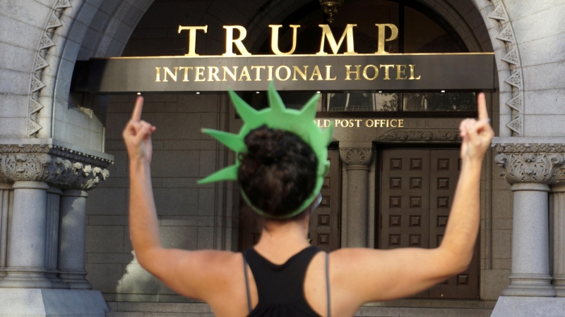 Una mujer realiza un gesto de desprecio frente al edificio Trump. - Reuters