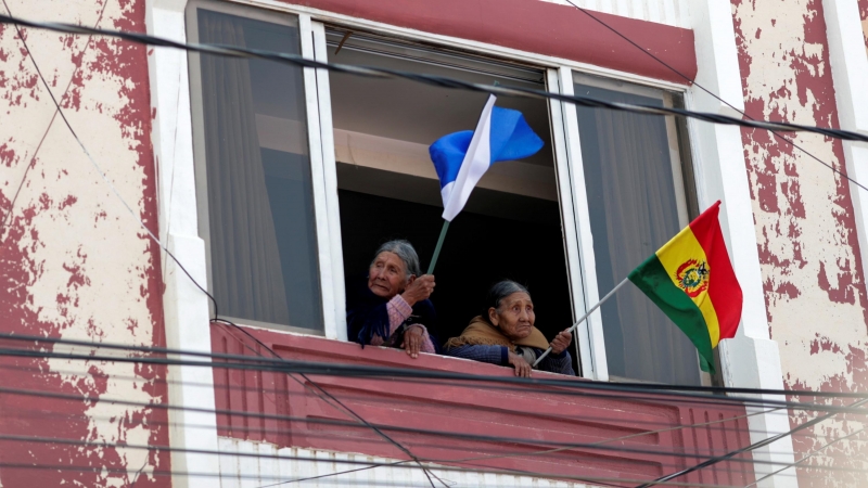 Dos mujeres en Villazon, zona de Bolivia frontera con Argentina, ondean banderas de ambos países.