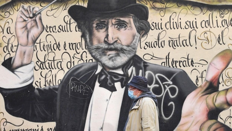 Un hombre pasa frente a un mural en Milán, Italia