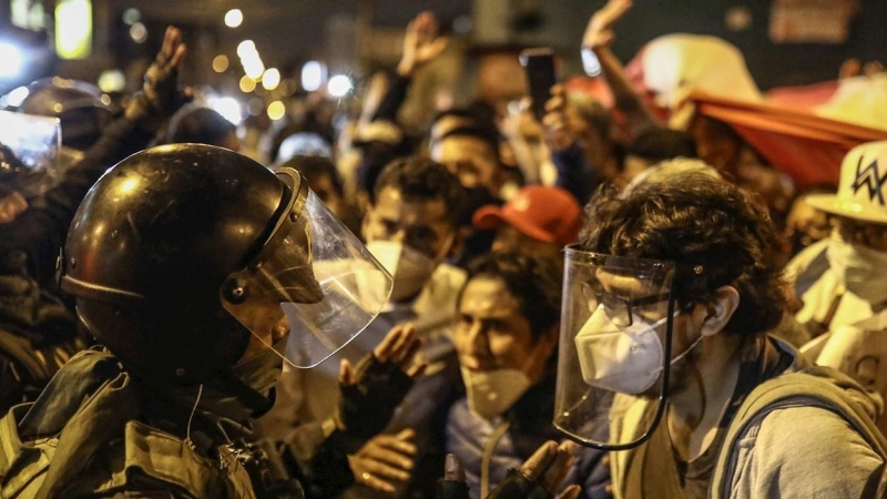Un manifestante y un agente de Policía hablan en una protesta contra Manuel Merino, en Lima (Perú).