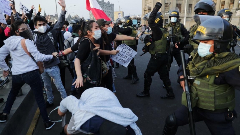 Manifestantes chocan con la policía durante las protestas tras el juicio político del presidente Martín Vizcarra, en Lima, Perú.