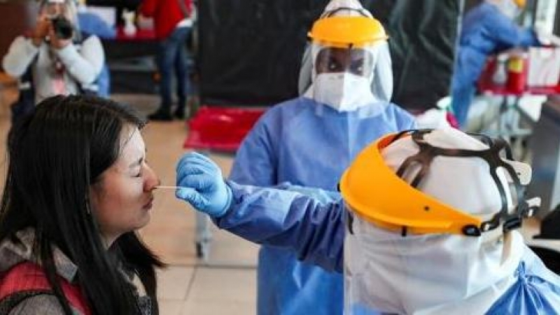 Personal médico realiza pruebas PCR en un aeropuerto