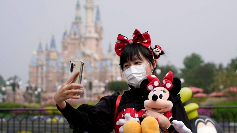 Una visitante se hace una foto frente al castillo de Disneyland Shanghai. Los parques temáticos han visto caer drásticamente las visitas por la covi-19.