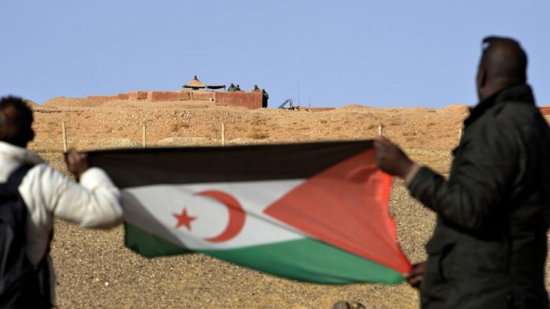 Fotografía de archivo de dos hombres sujetando la bandera del Frente Polisario en el Sáhara.