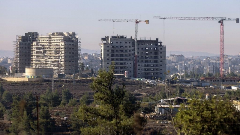 Nuevos edificios de apartamentos en construcción en el asentamiento de Beit El en la ocupada Cisjordania con la ciudad palestina de Ramallah al fondo.