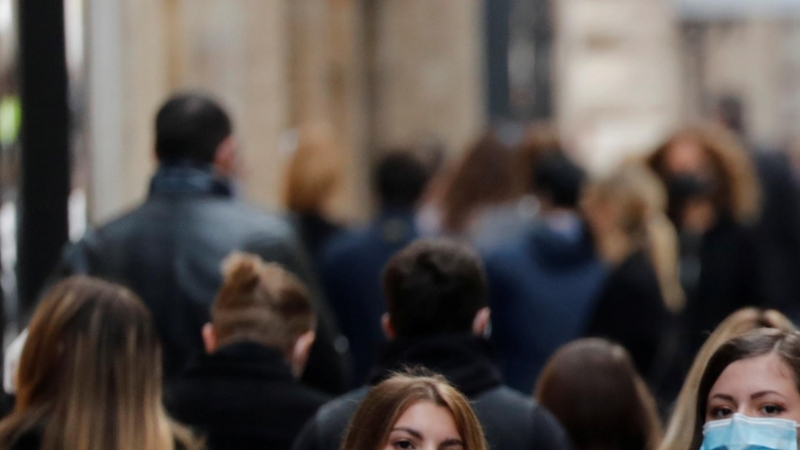 Varios transeúntes pasean por una calle de Roma, italia