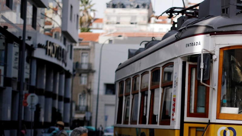 Una mujer conversa con el conductor de un tranvía en Lisboa, Portugal.