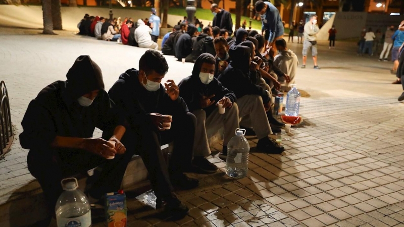 Un grupo de migrantes sentados frente a la Delegación del Gobierno en Las Palmas de Gran Canaria.