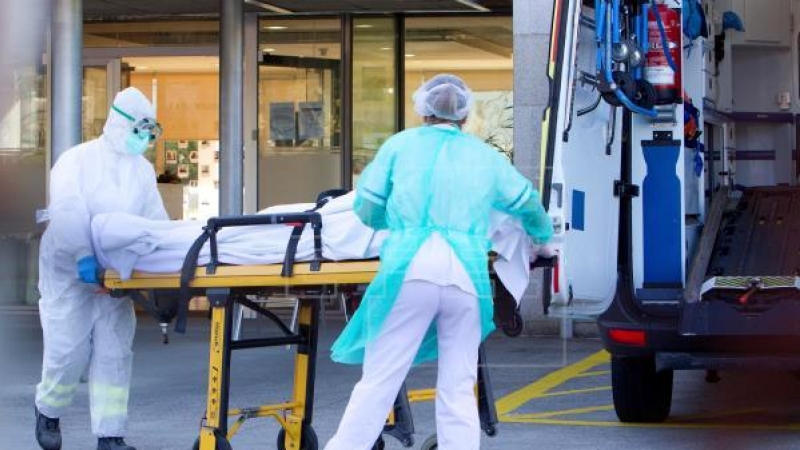 Dos enfermeros trasladan a un enfermo de covid a un hospital.