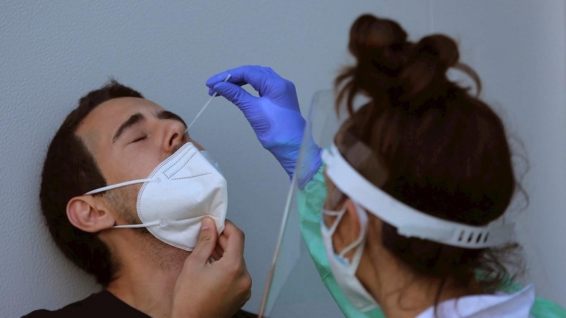 Personal sanitario realiza una prueba de PCR a un hombre, en una imagen de archivo.