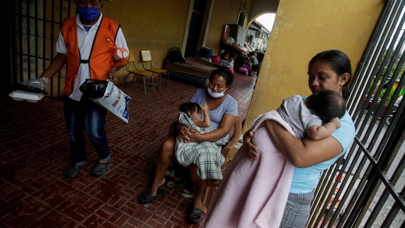 Mujeres cargan a sus bebés en una escuela que se utiliza como refugio a medida que se acerca la tormenta Iota, en Choluteca, Honduras, 17 de noviembre de 2020.