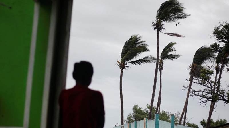 Un hombre observa palmeras mecidas por el viento cuando se acerca la tormenta Iota, en Cedeño