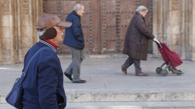 Personas se protegen del intenso frío hoy en el centro de València.