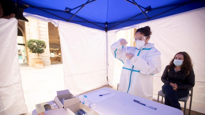 18/11/2020.- Una mujer se realiza una PCR en uno de los puntos habilitados por la Cambra de Comerç de Barcelona para realizar test rápidos de antígenos.
