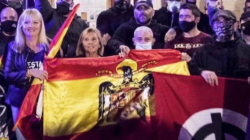 Varios ultraderechistas sostienen una bandera franquista en el acceso a la Iglesia de Benimaclet, el pasado 12 de octubre.