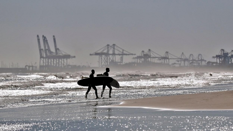 Dos surfistas salen de la playa de La Malvarrosa de València donde las olas y el cielo despejado han animado a numerosas practicantes de este deporte a acercarse al mar.