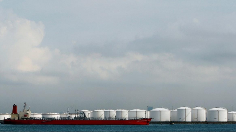 Un barco amarrado cerca de tanques de almacenamiento en una refinería de petróleo frente a la costa de Singapur. REUTERS/Vivek Prakash