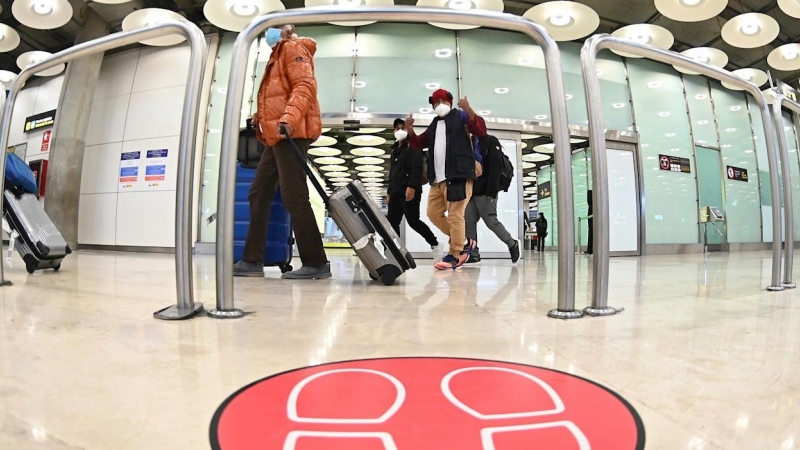Pasajeros caminan por el aeropuerto Adolfo Suárez-Barajas en Madrid donde comienza la exigencia de pruebas PCR para pasajeros de vuelos de fuera de España.