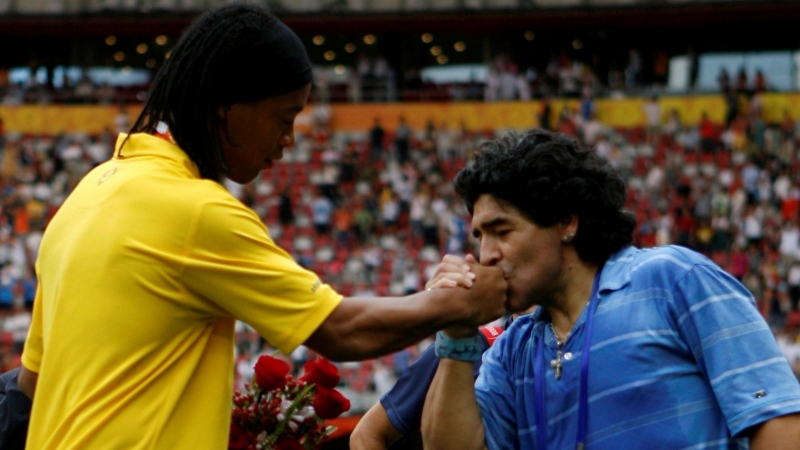 El exfutbolista argentino Diego Maradona besa la mano del brasileño Ronaldinho tras la ceremonia de entrega de medallas de fútbol masculino en los Juegos Olímpicos de Beijing 2008 Agosto