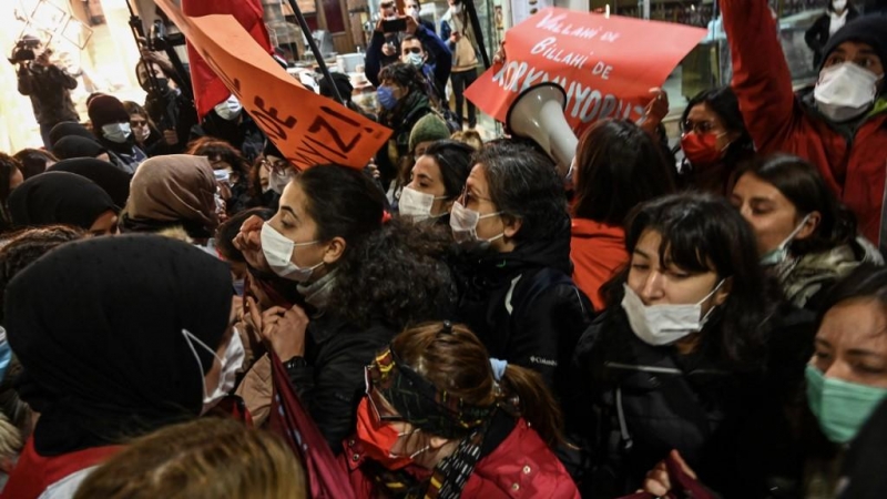 Mujeres manifestantes chocan con agentes de Policía cuando intentan pasar la barricada para seguir marchando por la avenida Istiklal, en Estambul.
