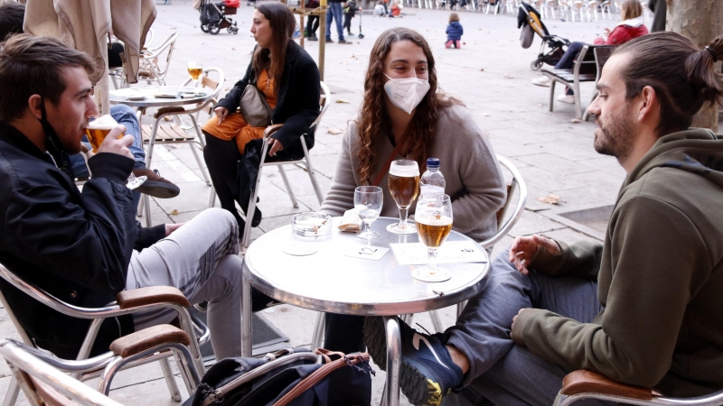 Unos joves prenent una cervesa tomando a la plaça de la Virreina (Barcelona).