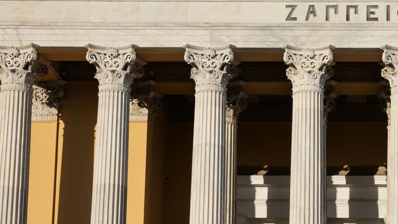 Imagen de varias personas sentadas en las escaleras del edificio Zappeion en Atenas, Grecia