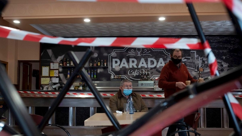 26/11/2020.- Un camarero atiende a un cliente en el interior de un bar de Verín, donde se ha reabierto la hostelería y ha finalizado el cierre perimetral.