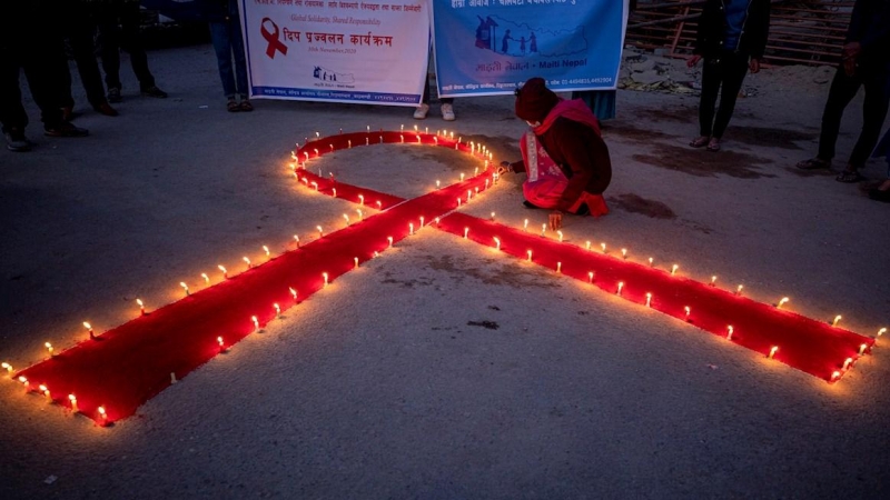 Mujeres y niños del orfanato de rehabilitación para aquellos que sufren de sida (VIH) 'Maiti Nepal', encienden varias velas.