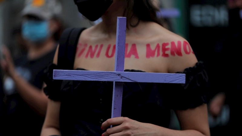 Una mujer marcha con una cruz durante una manifestación con motivo del Día Internacional de la Eliminación de la Violencia contra las Mujeres hoy, en Ciudad de Panamá
