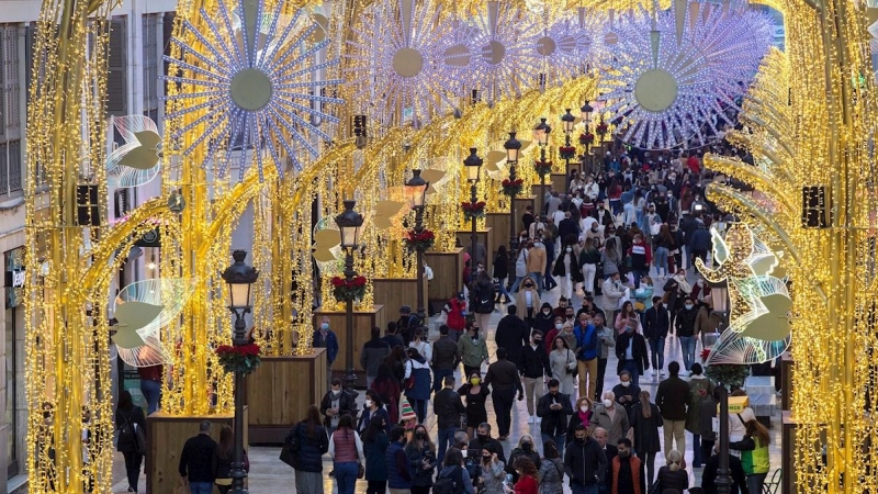 Numerosas personas observan el alumbrado de Navidad de la calle Larios, en Málaga.