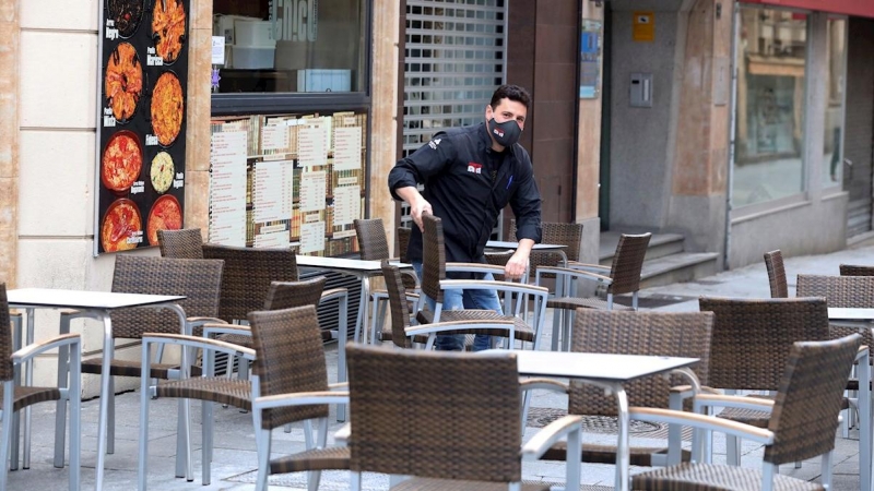 Un camarero prepara la terraza de un bar de Salamanca. Castilla y León ha abierto este viernes las terrazas de la hostelería, salvo en la capital burgalesa.