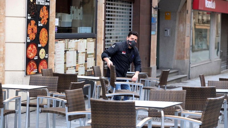 Un camarero prepara la terraza de un bar de Salamanca. Castilla y León ha abierto este viernes las terrazas de la hostelería, salvo en la capital burgalesa.