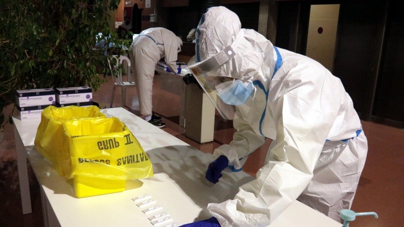 Un professional sanitari dipositant una mostra en un test d'antígens al pavelló Onze de Setembre de Lleida.