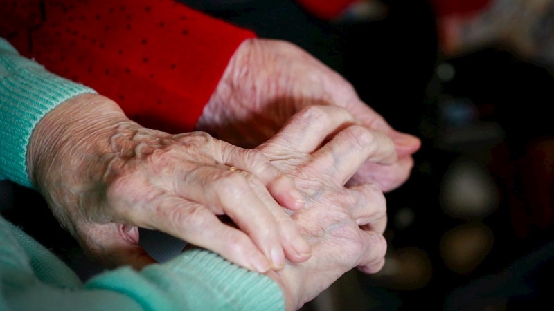 03/12/2020. Imagen de archivo de dos personas mayores cogidas de la mano. - EFE