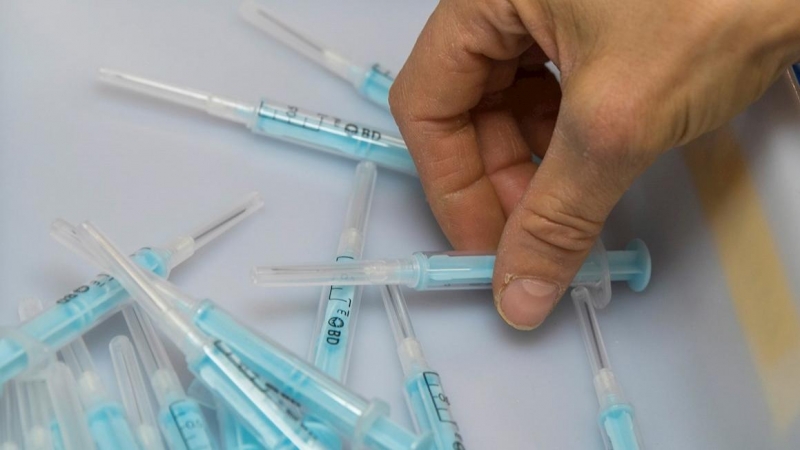 Una operaria de la planta de la empresa Becton Dickinson de Fraga (Huesca), inspecciona unas muestras de la jeringuilla que fabrican para administrar la vacuna contra el coronavirus.