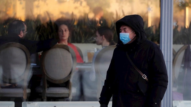 09/12/2020.- Un hombre ruso con mascarilla pasa frente a un restaurante en San Petersburgo.