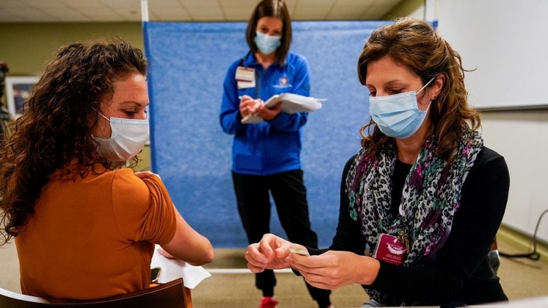 En Indiana, una mujer recibe una dosis de vacuna contra la covid-19.