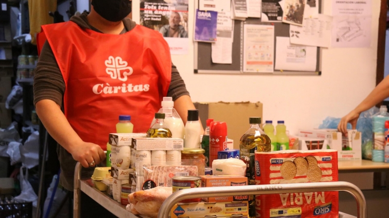 Un carro ple menjar a un punt de distribució d'aliments de Cáritas a Les Corts.