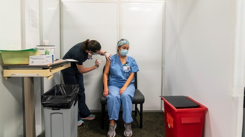 Una enfermera de la Universidad de Washignton administra la vacuna de Pfizer-BioTech a una compañera en un centro médico de la Universidad de Washington en Seattle.
