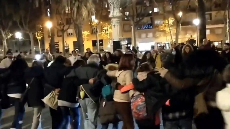 Un grupo de negacionistas cantan y bailan abrazados en el centro de Barcelona.